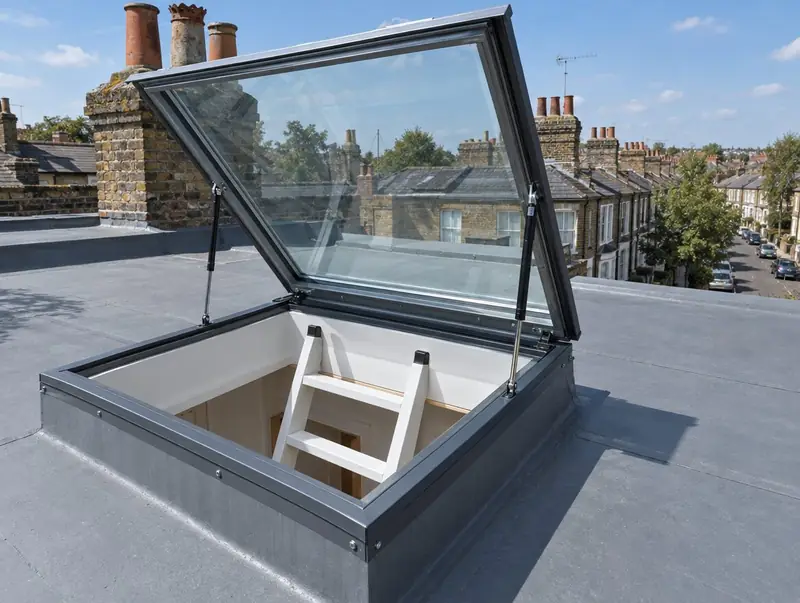 Glazed roof access hatch held open on gas struts above a loft ladder